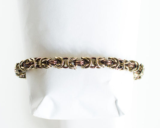 Brass and copper chain bracelet on a white mannequin arm