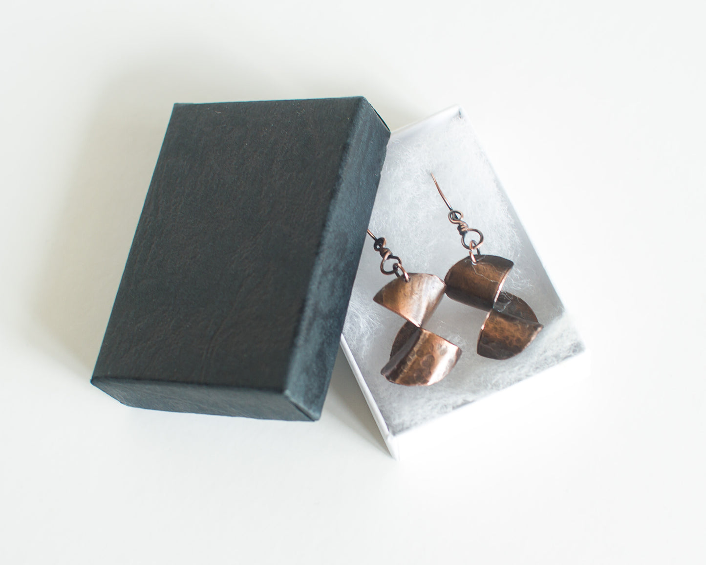 copper earrings in a black and white box on a white background