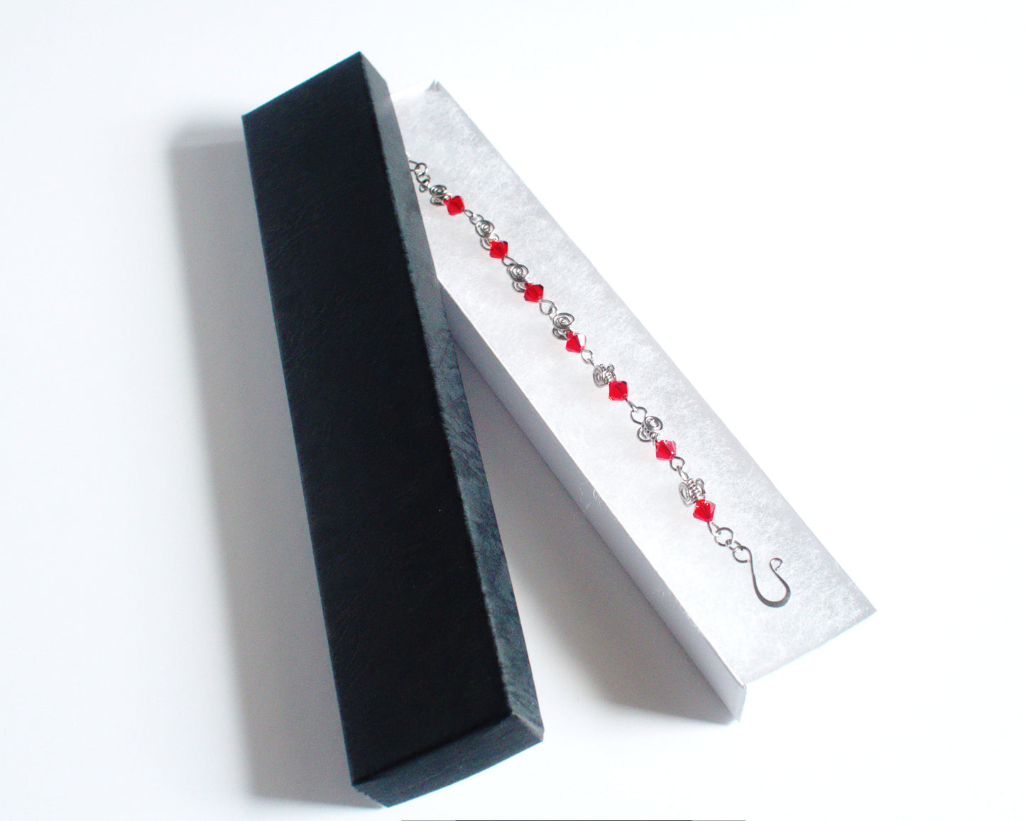 Jewelry box with a red beaded bracelet on a white background
