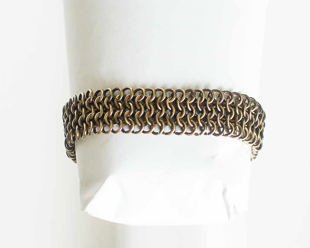 Brass chainmail bracelet on a white surface