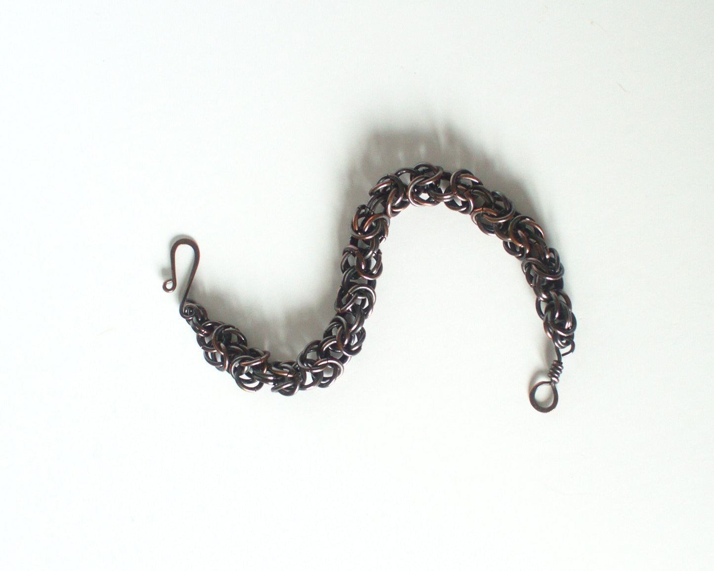 Bracelet made of interlinked copper rings on a white background