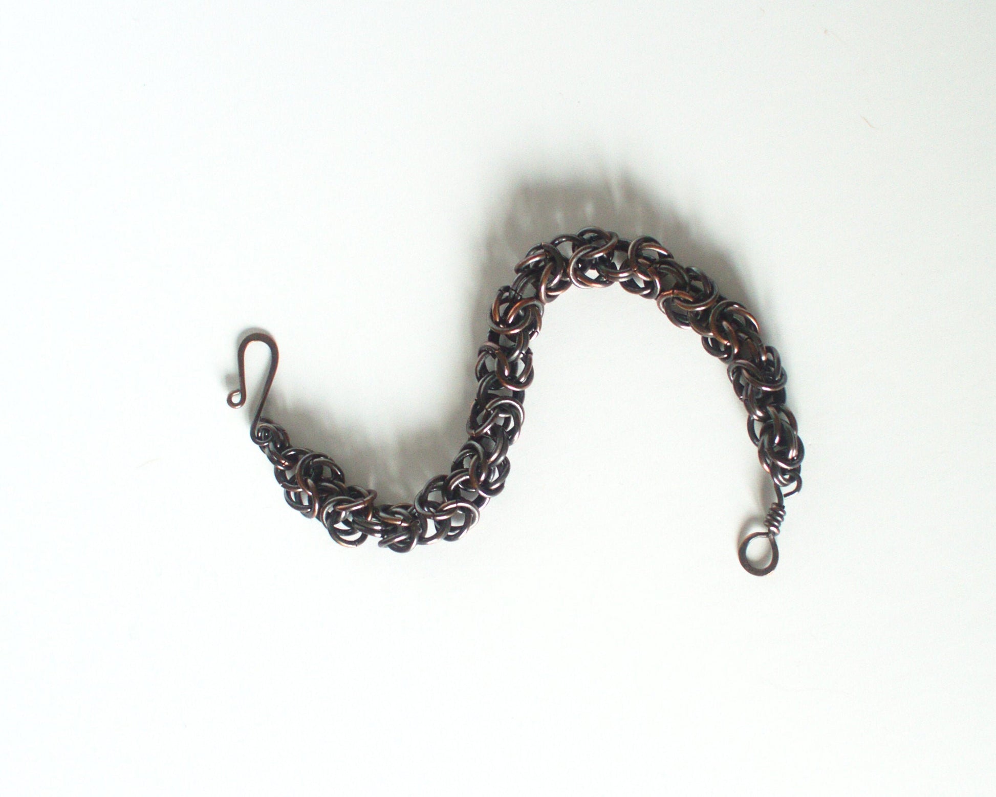 Bracelet made of interlinked copper rings on a white background