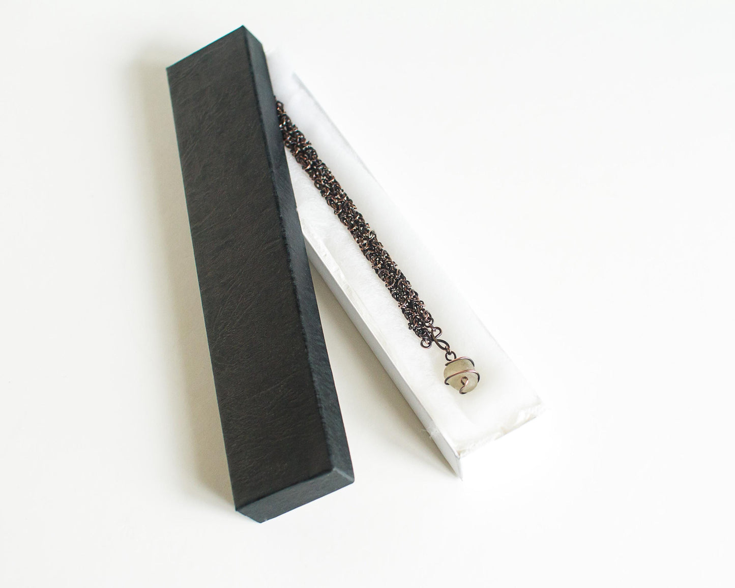 Necklace with a pendant in a black box on a white background