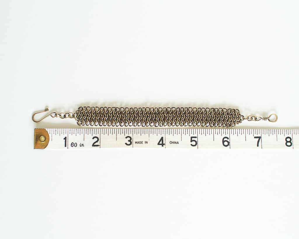 Brass chainmail bracelet with a tape measure for size reference - showing a length of 7.5 inches or 19cm.