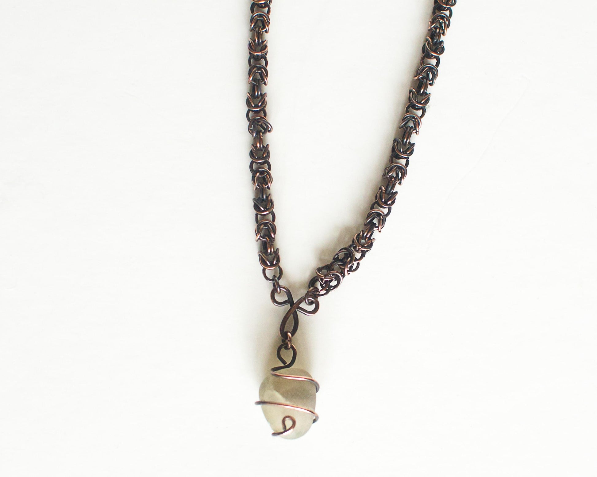 Copper necklace with a unique pendant on a white background