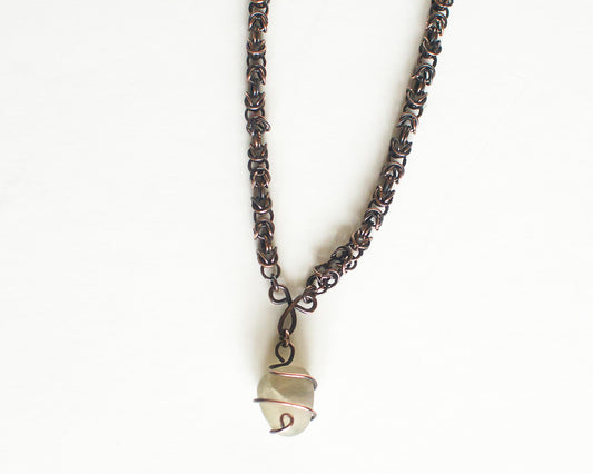 Copper necklace with a unique pendant on a white background