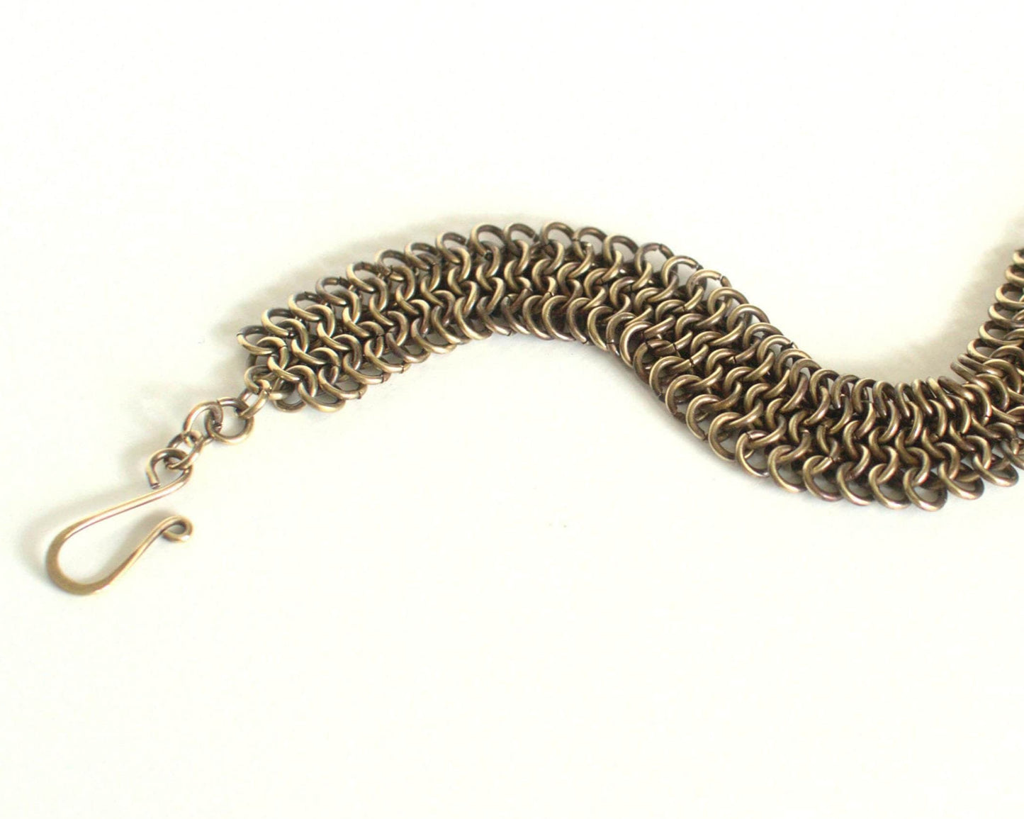 Brass chainmail bracelet with clasp on a white background