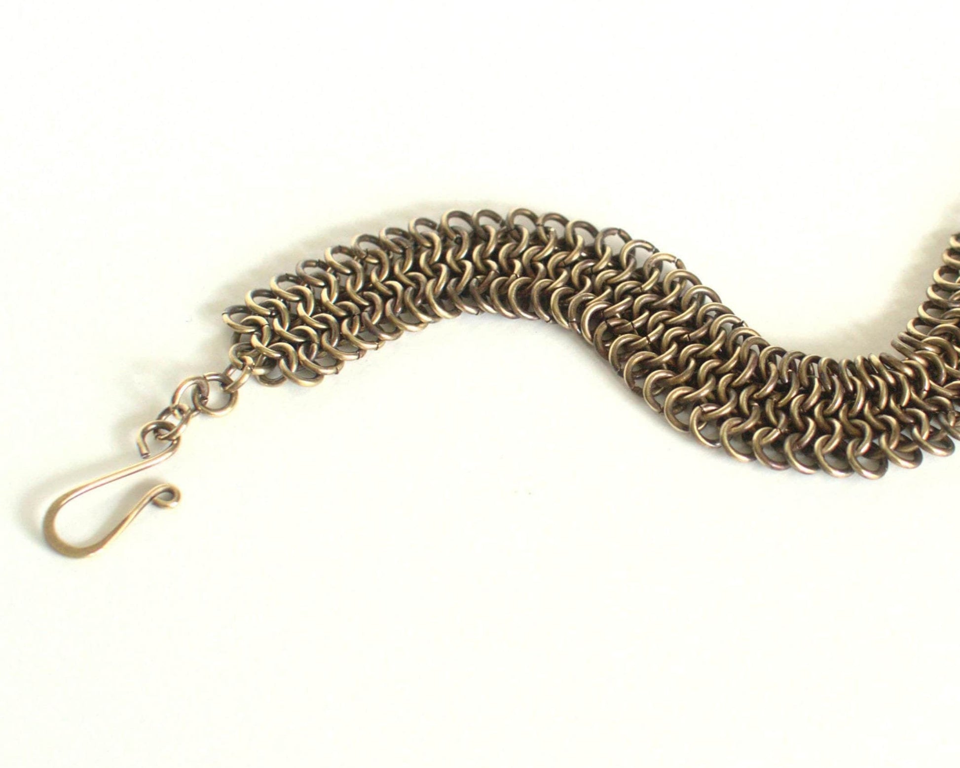 Brass chainmail bracelet with clasp on a white background