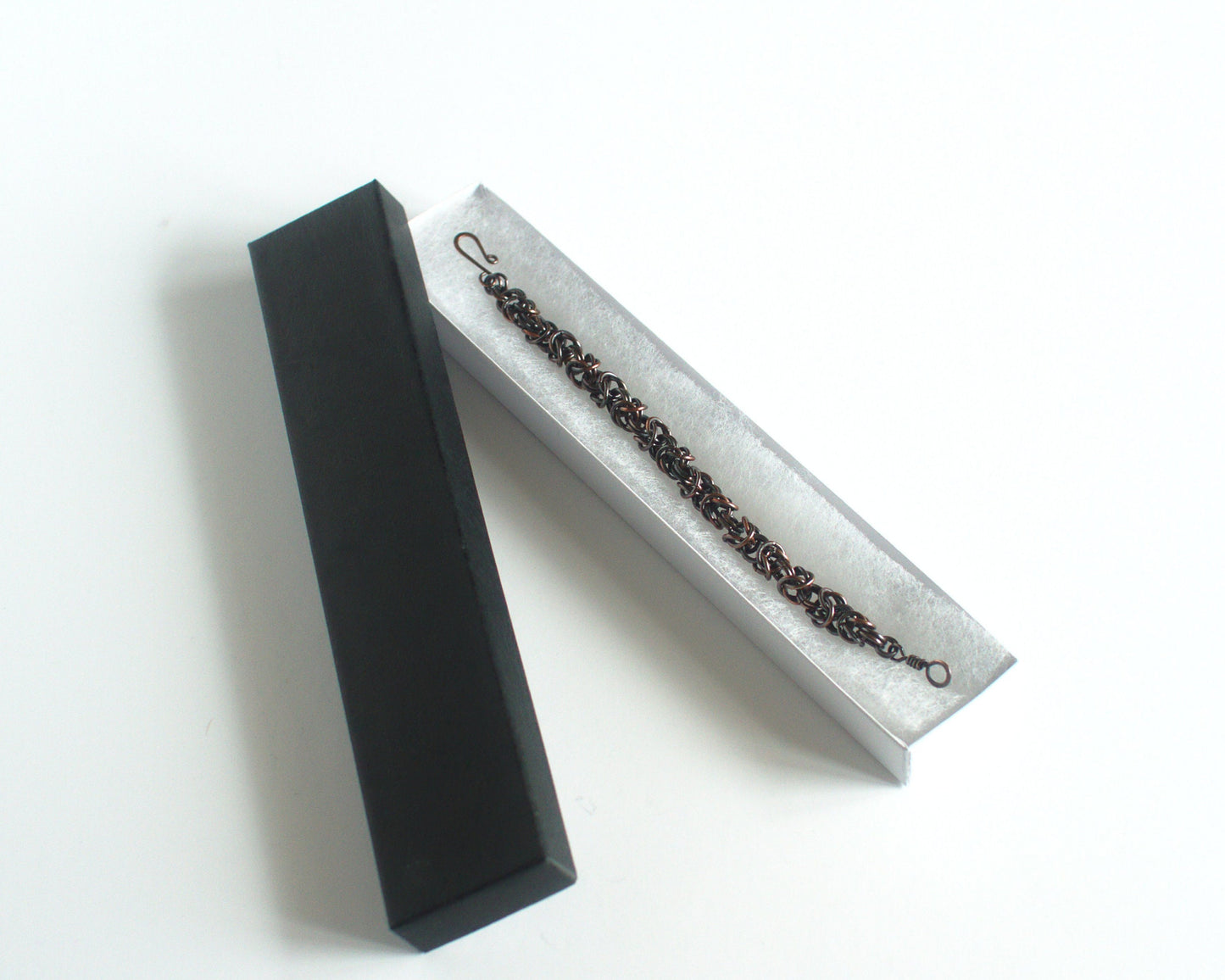 copper bracelet in a white box with black lid on a white background
