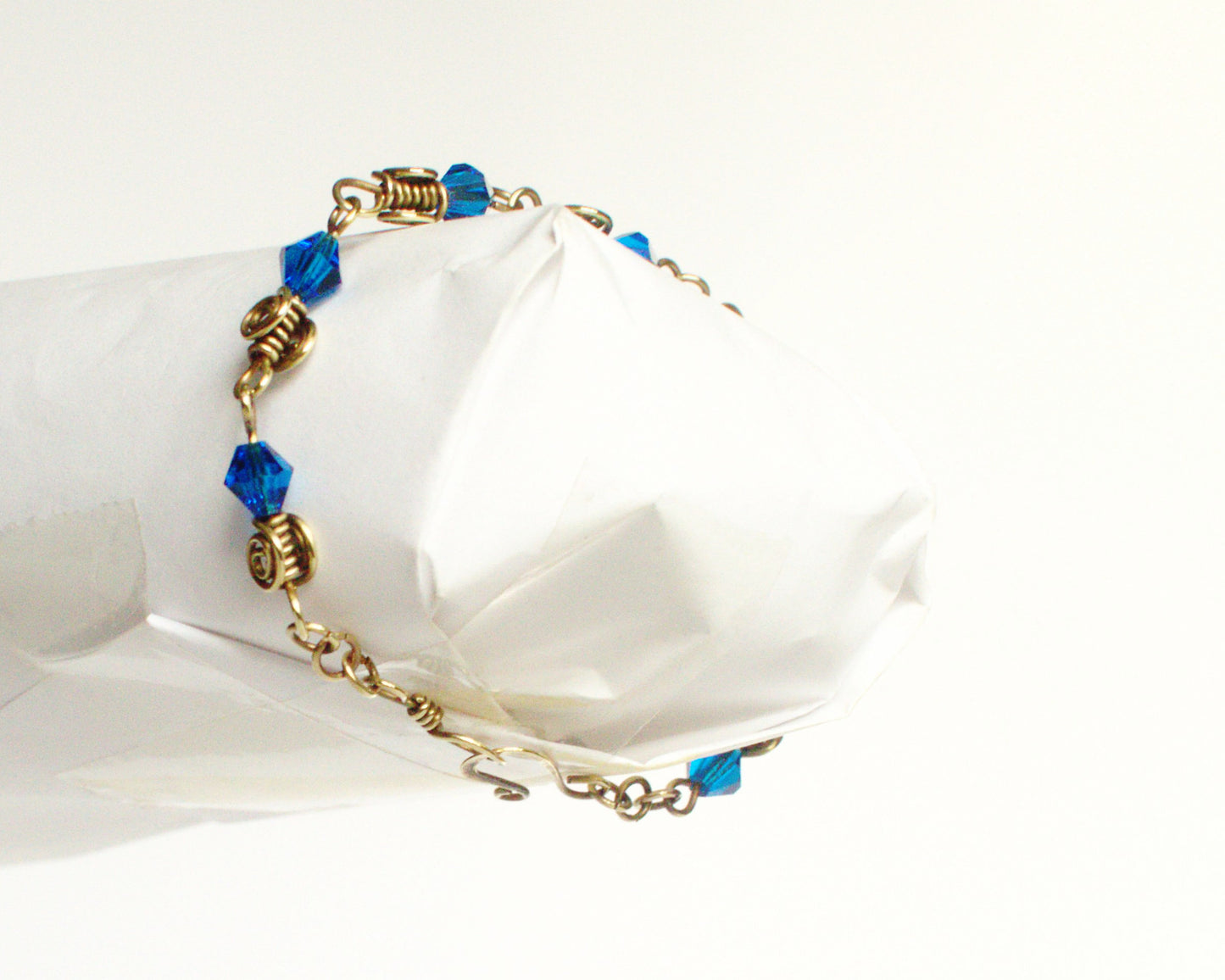 Bracelet with blue beads and gold accents on a white background
