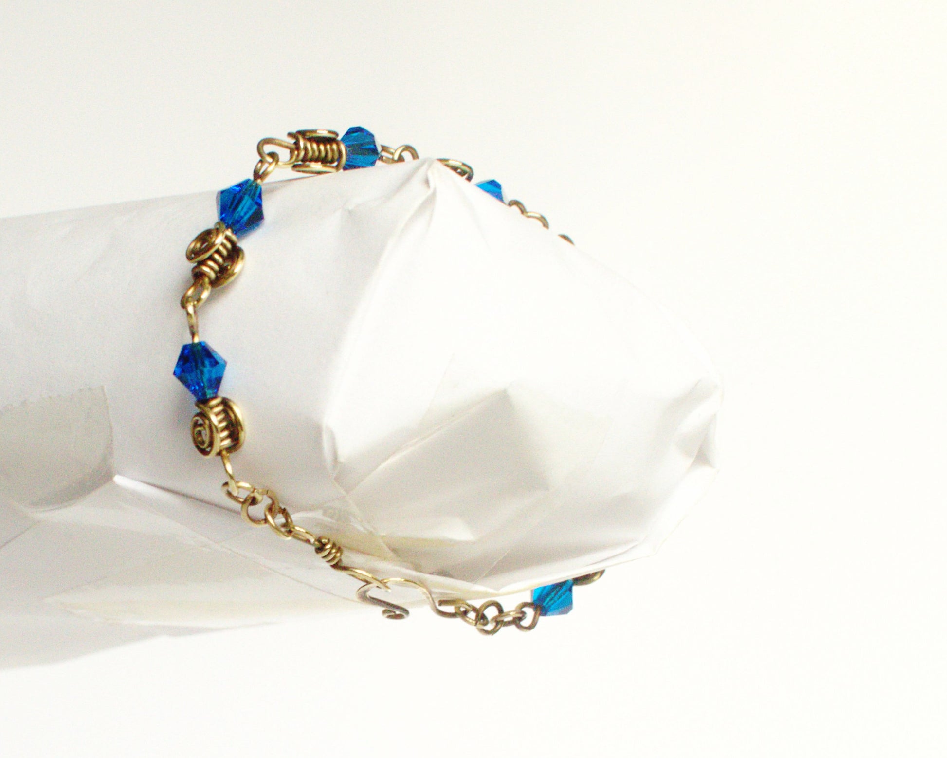 Bracelet with blue beads and gold accents on a white background