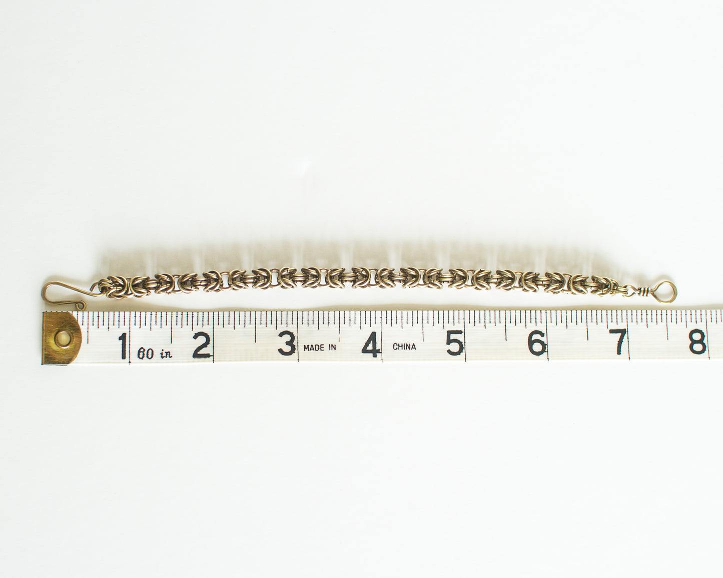 Brass chain bracelet with measuring tape - showing a length of 7.5 inches or 19cm.