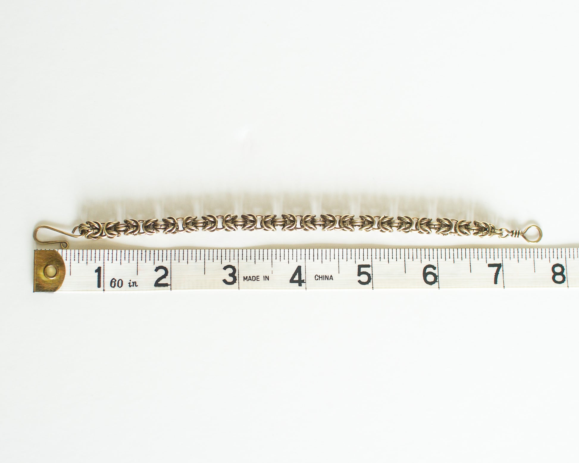 Brass chain bracelet with measuring tape - showing a length of 7.5 inches or 19cm.