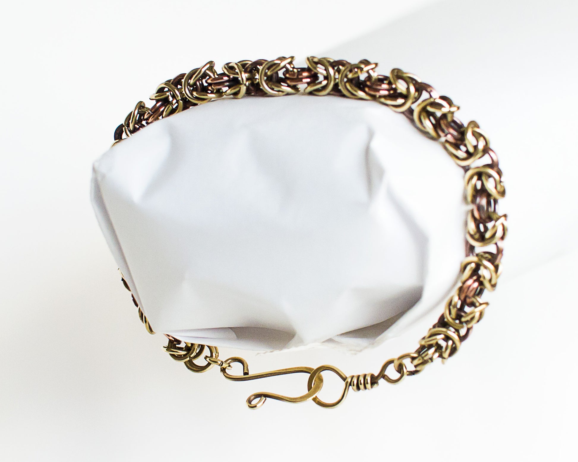Brass and copper chain bracelet on a white mannequin hand