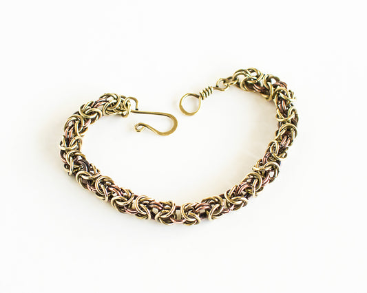 Brass and copper chain bracelet on a white background