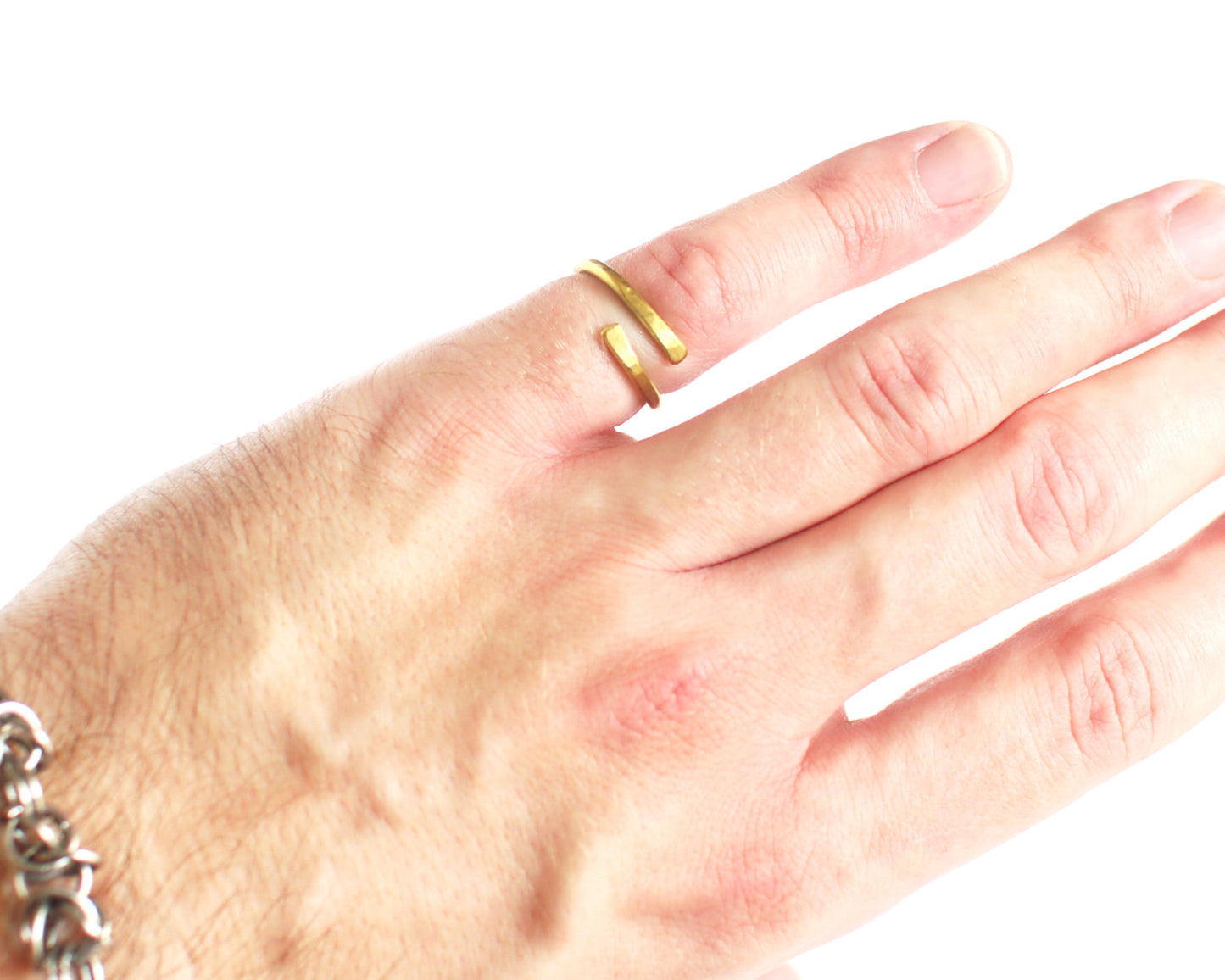 Hand wearing a brass ring on a white background