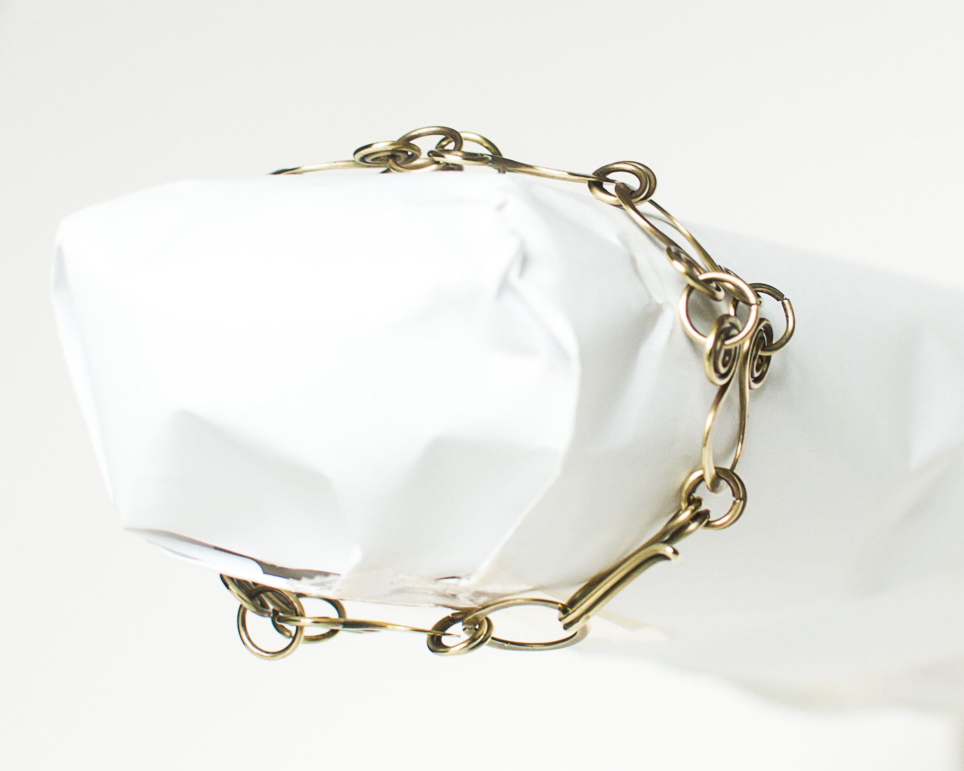 Brass chain bracelet on a white surface
