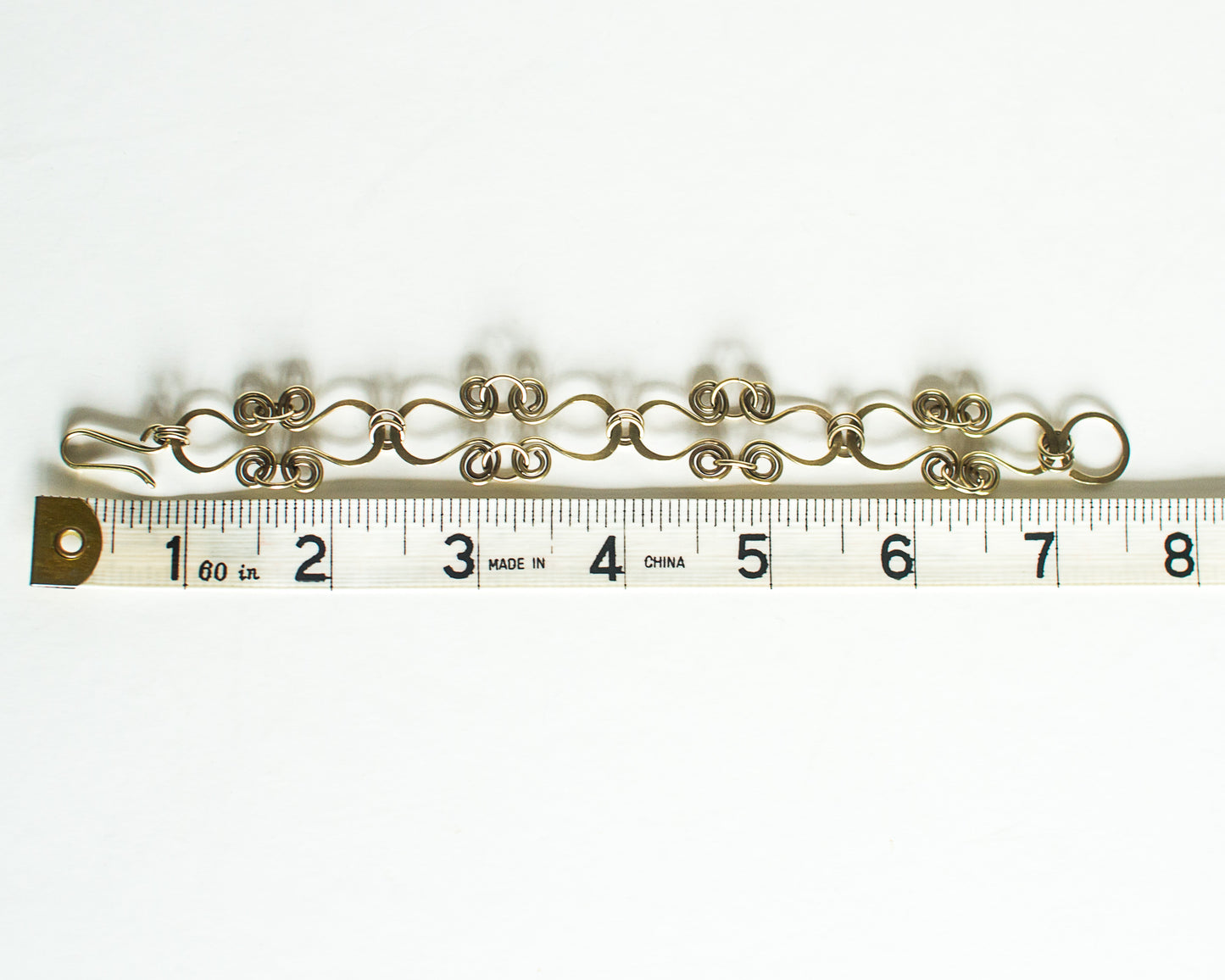 Brass bracelet on a ruler for size reference - showing a length of 7.5 inches or 19cm