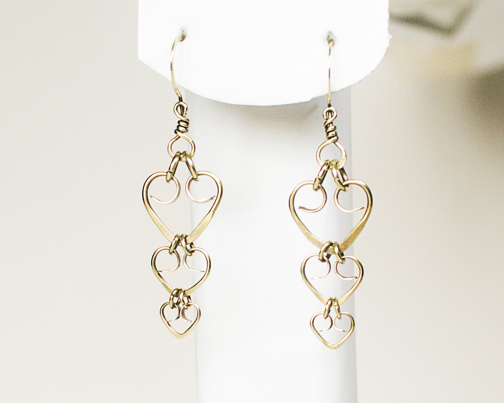 Brass heart-shaped earrings on a white background