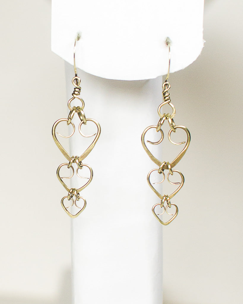Brass heart-shaped earrings on a white background