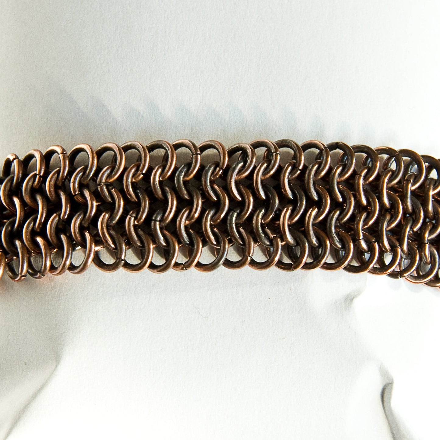 Copper chain bracelet on a mannequin with a white background