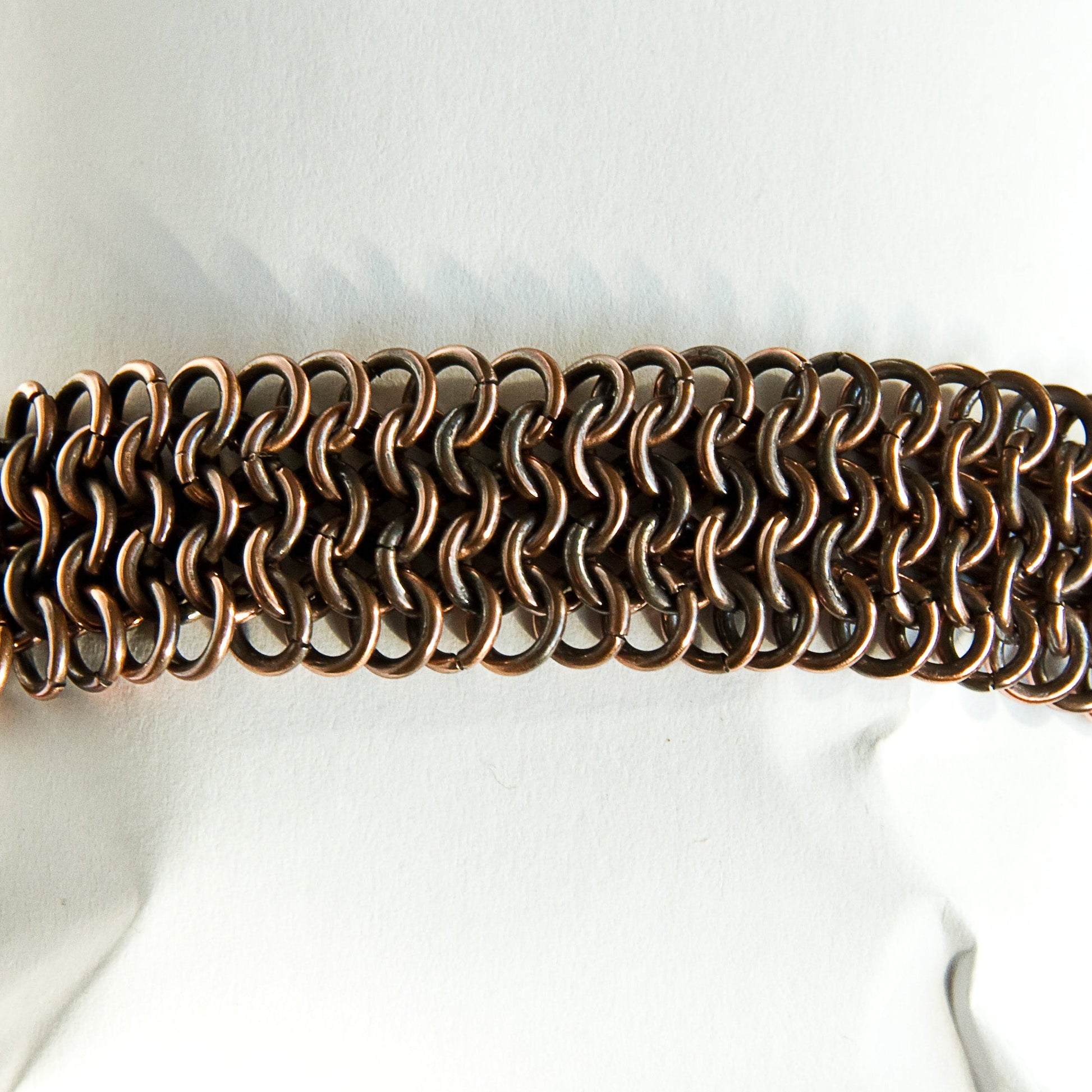 Copper chain bracelet on a mannequin with a white background