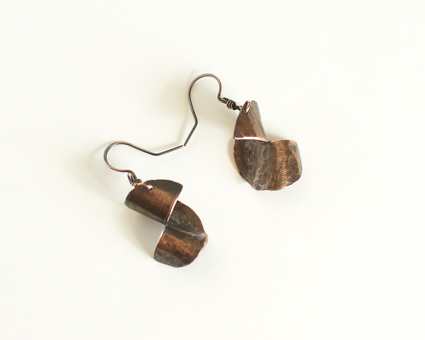 Copper Earrings with a 3 dimensional form, copper ear-wires on a white background
