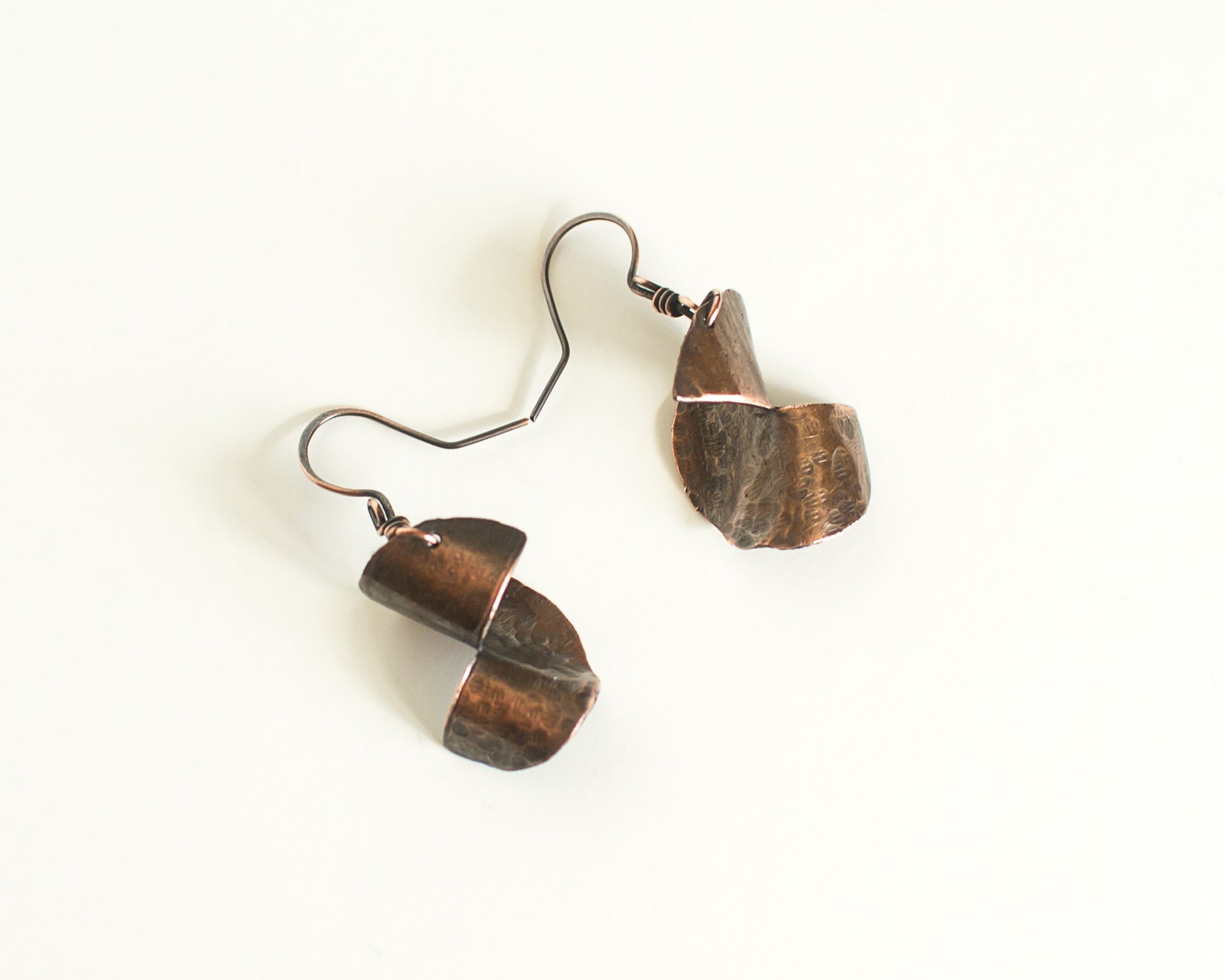 Copper Earrings with a 3 dimensional form, copper ear-wires on a white background