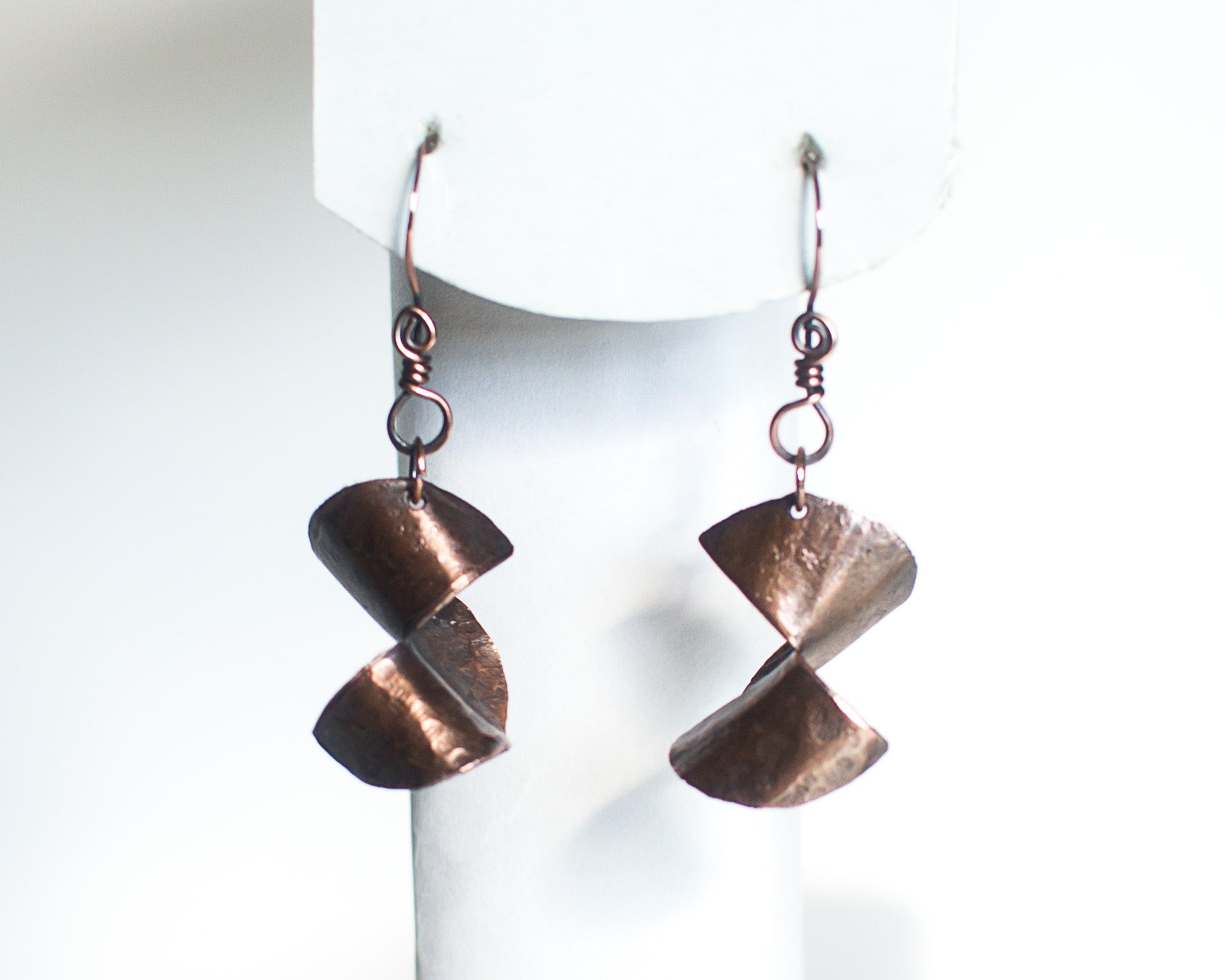 copper earrings on a white form showing how they would naturally hang from the ear.