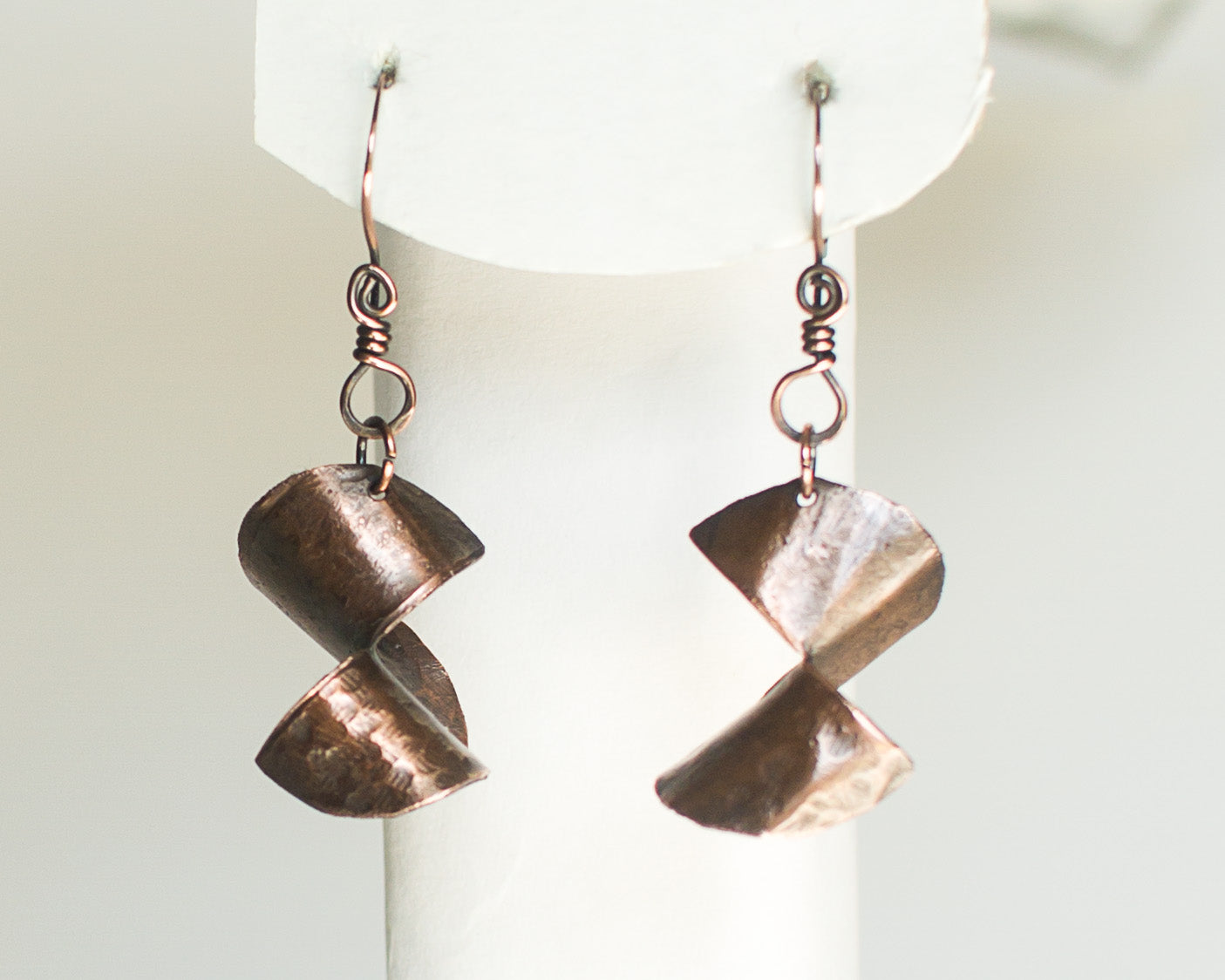 Copper earrings on a white form and white background