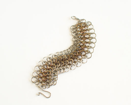 Chainmaille bracelet with a mix of silver and gold colors on a white background