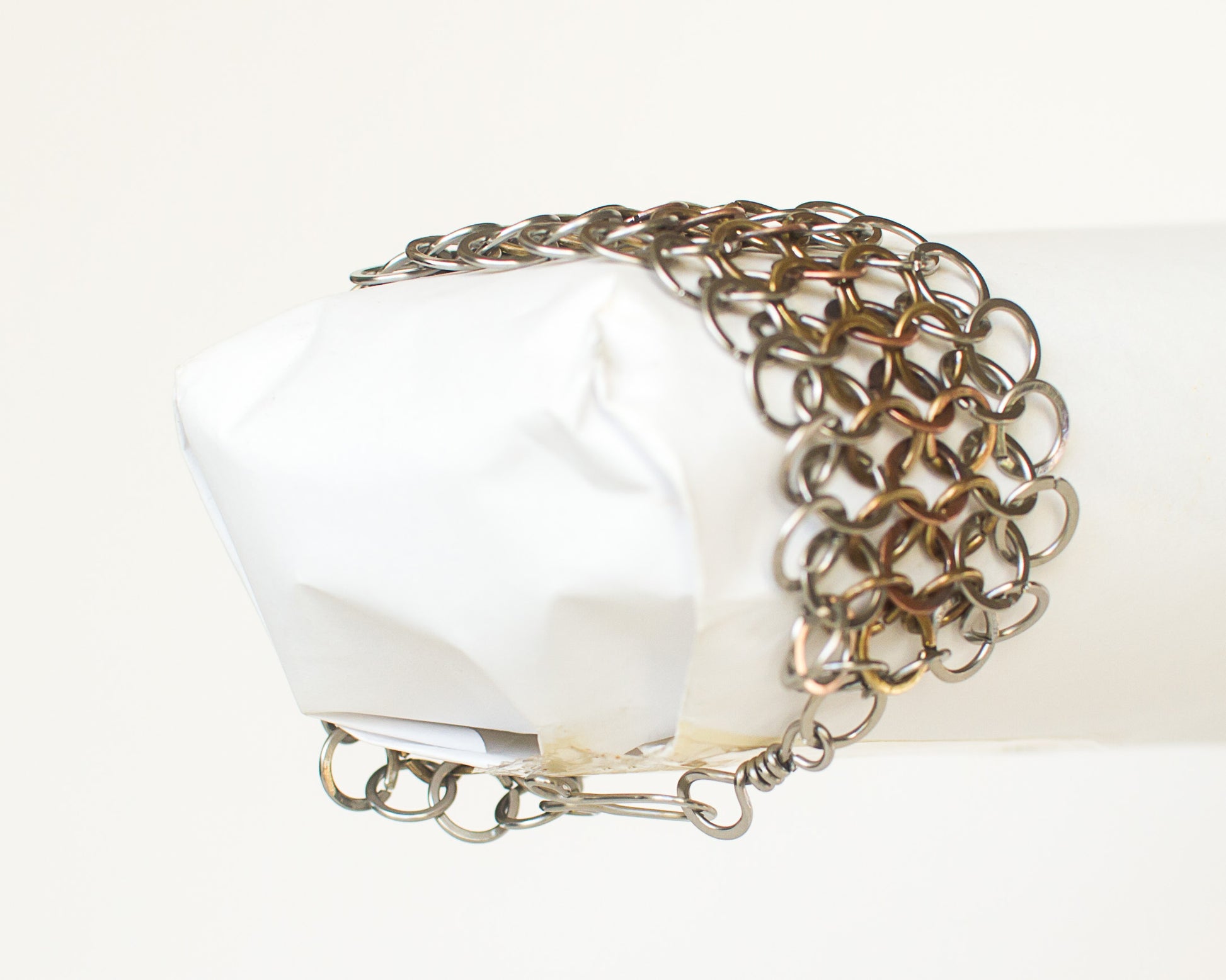 Metallic chainmail bracelet on a white background