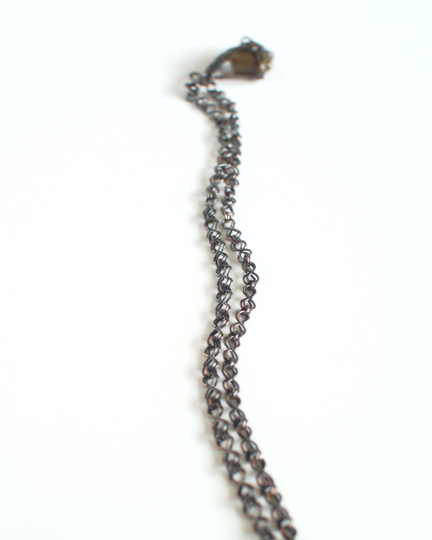 Close-up of a chain necklace with a clasp on a white background