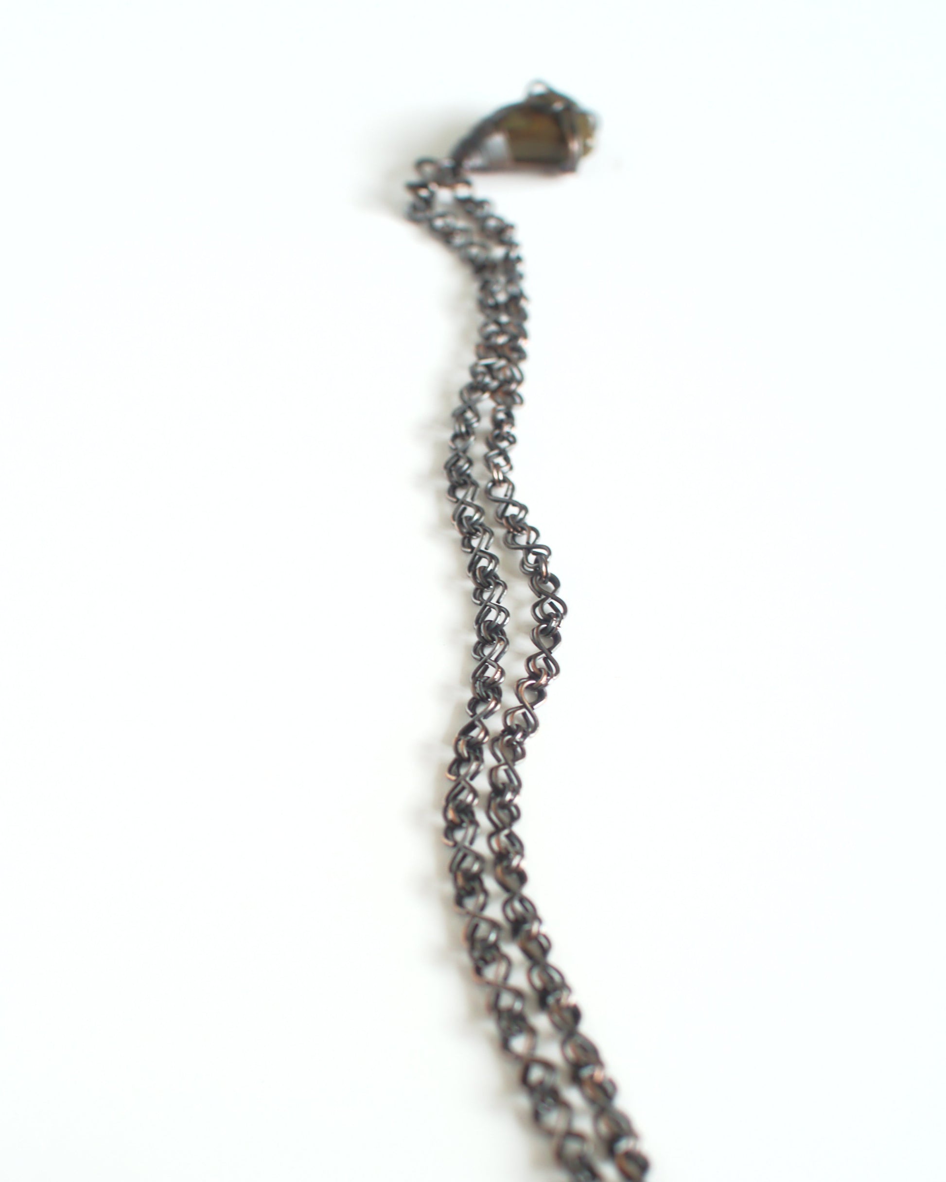 Close-up of a chain necklace with a clasp on a white background