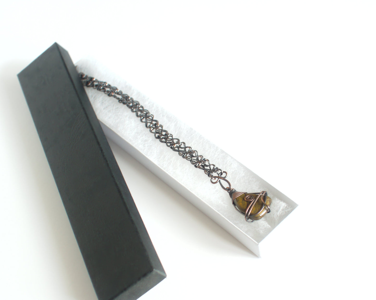 Necklace with a pendant in a black box on a white background