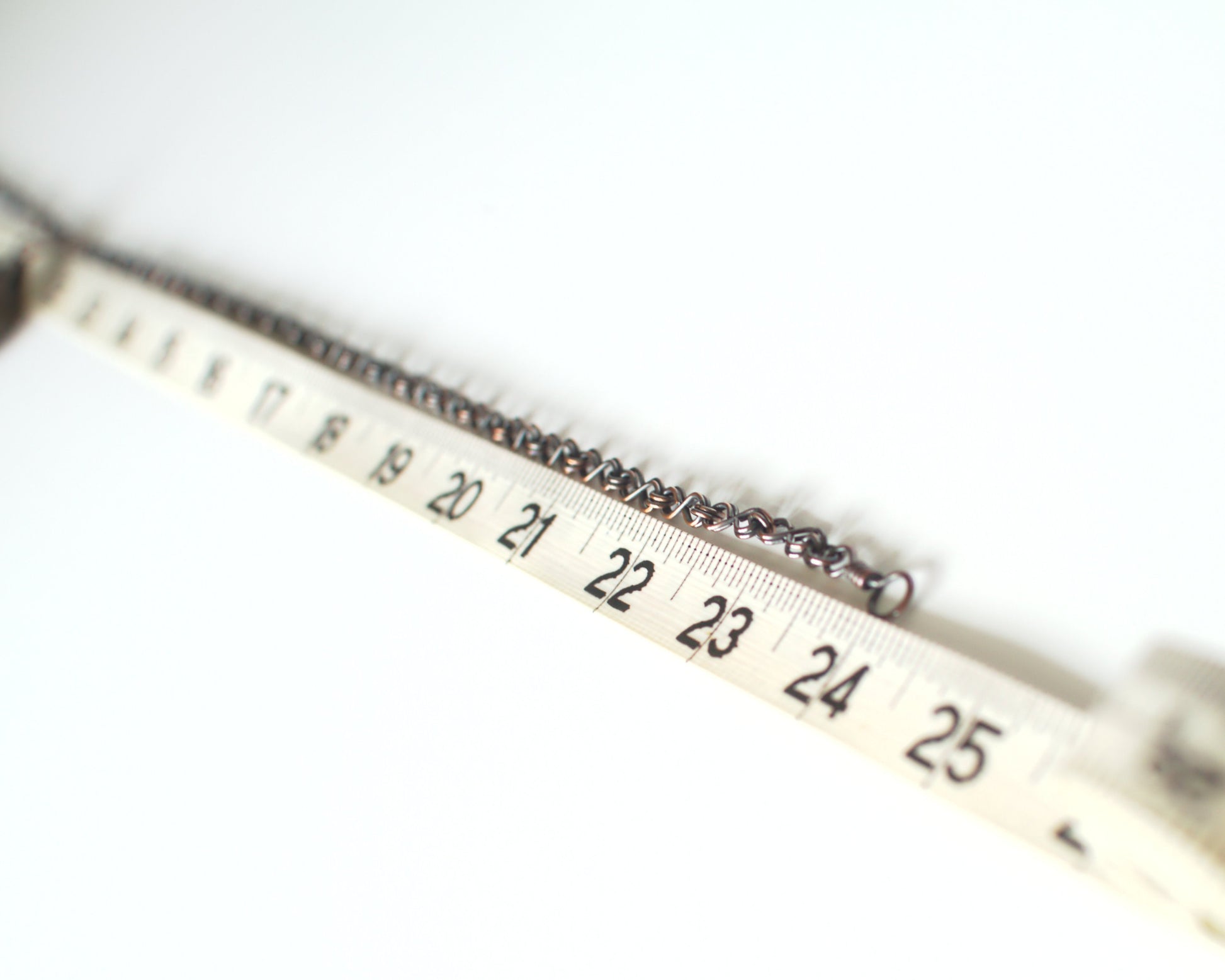 Close-up of a measuring tape showing a necklace of 24 inches or 60cm on a white background