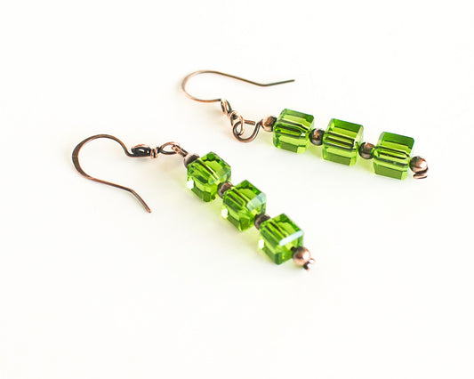 Copper and green glass cube beaded earrings on a white background