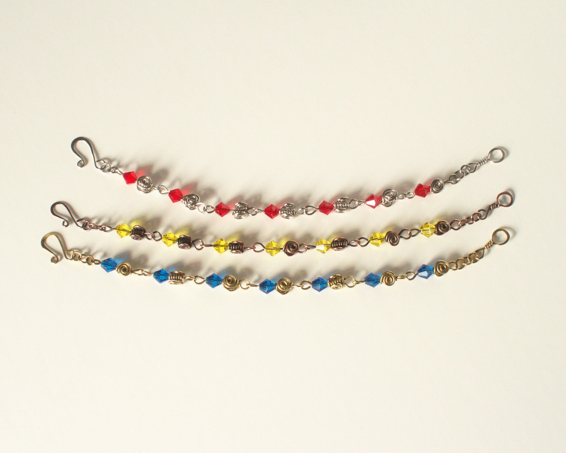 Three beaded bracelets with colorful beads on a white background - showing that other colours and styles are available