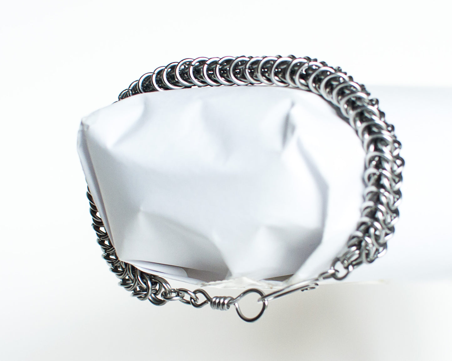 Steel chain bracelet on a white mannequin wrist with a white background
