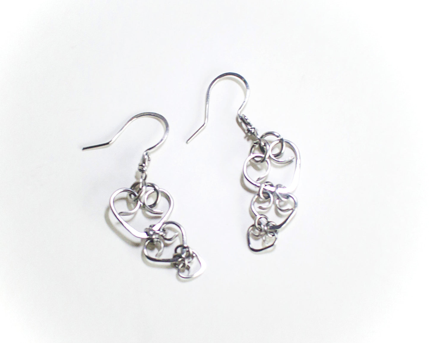 Pair of steel heart-shaped earrings on a white background