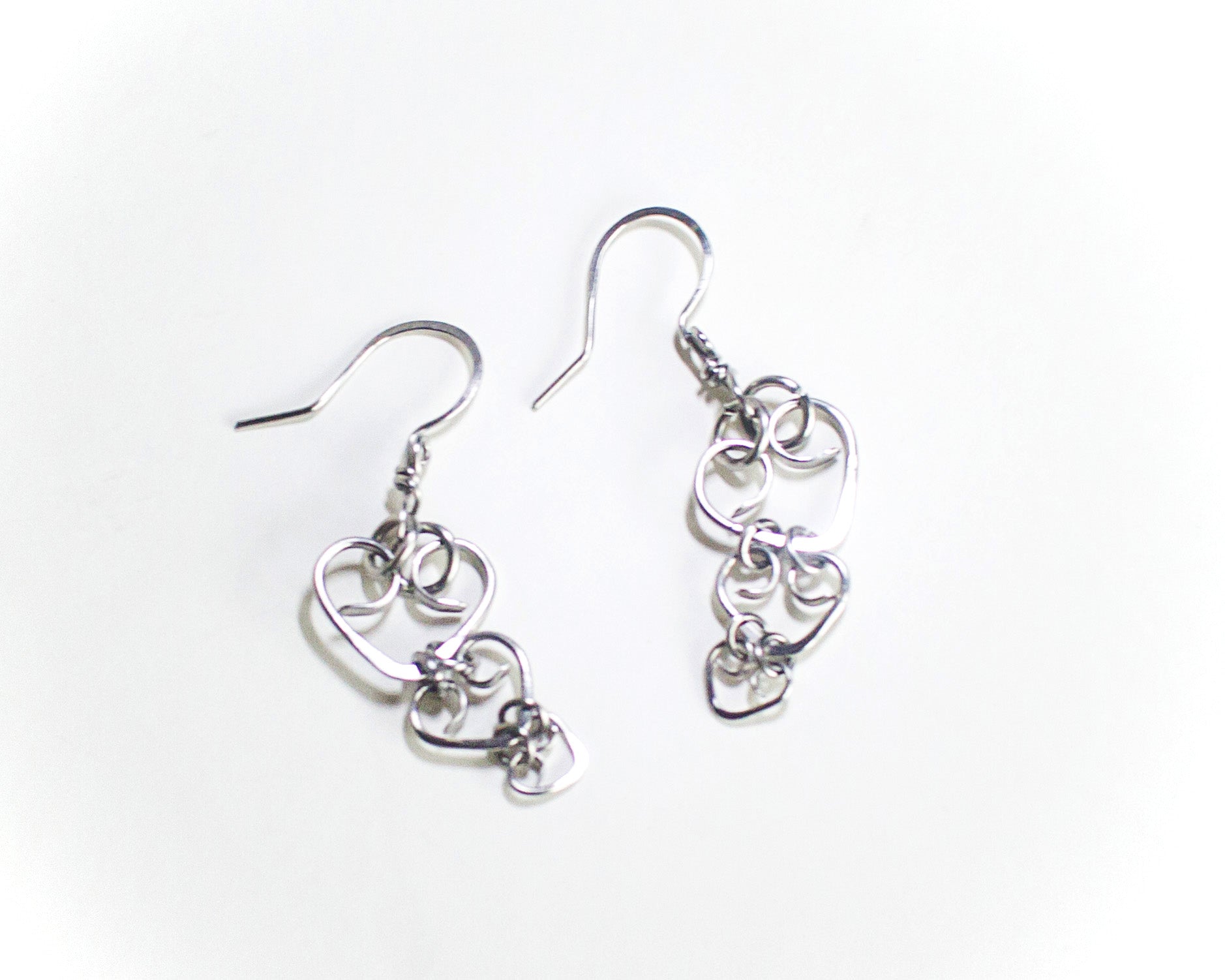 Pair of steel heart-shaped earrings on a white background