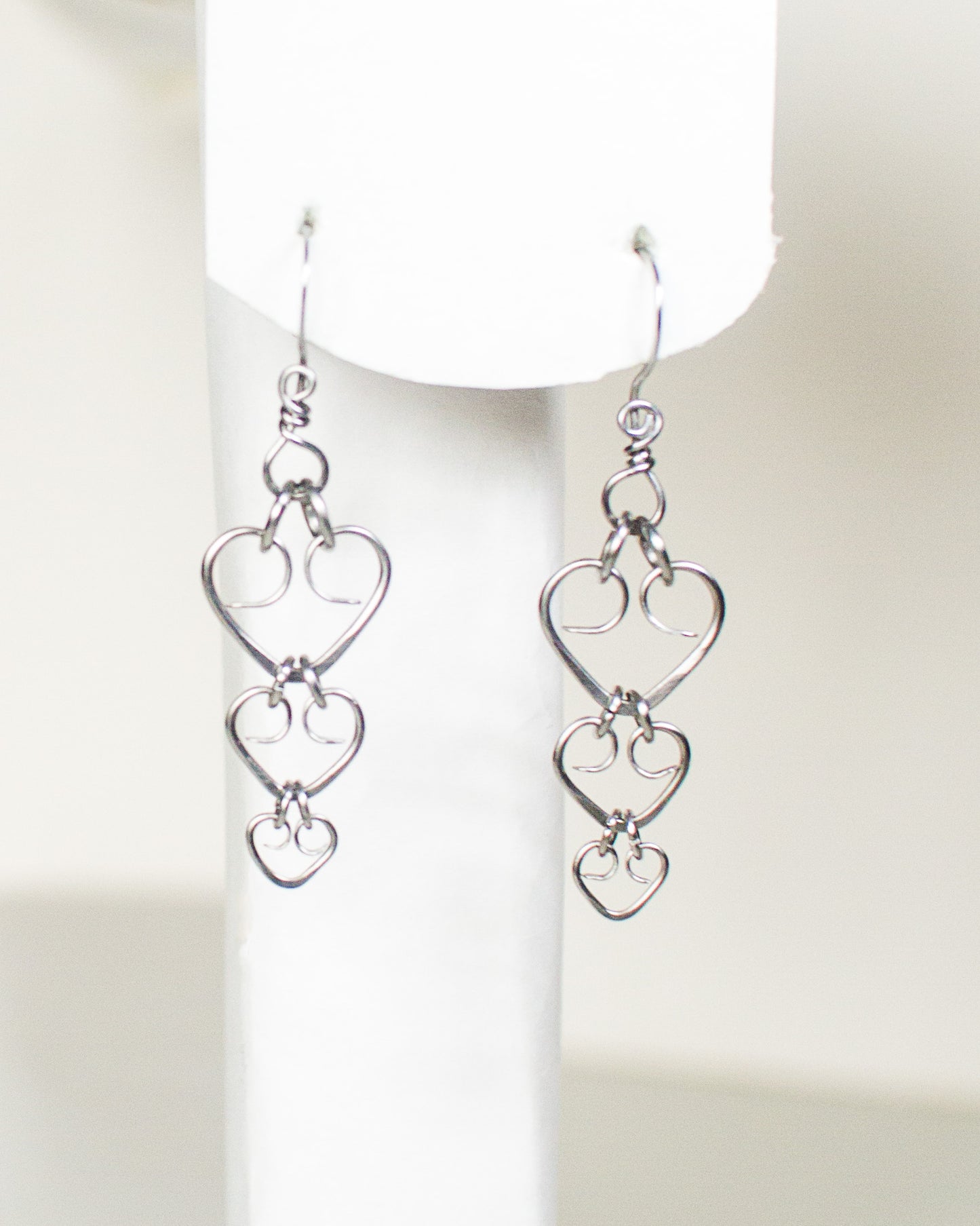 Pair of steel heart-shaped earrings on a white background