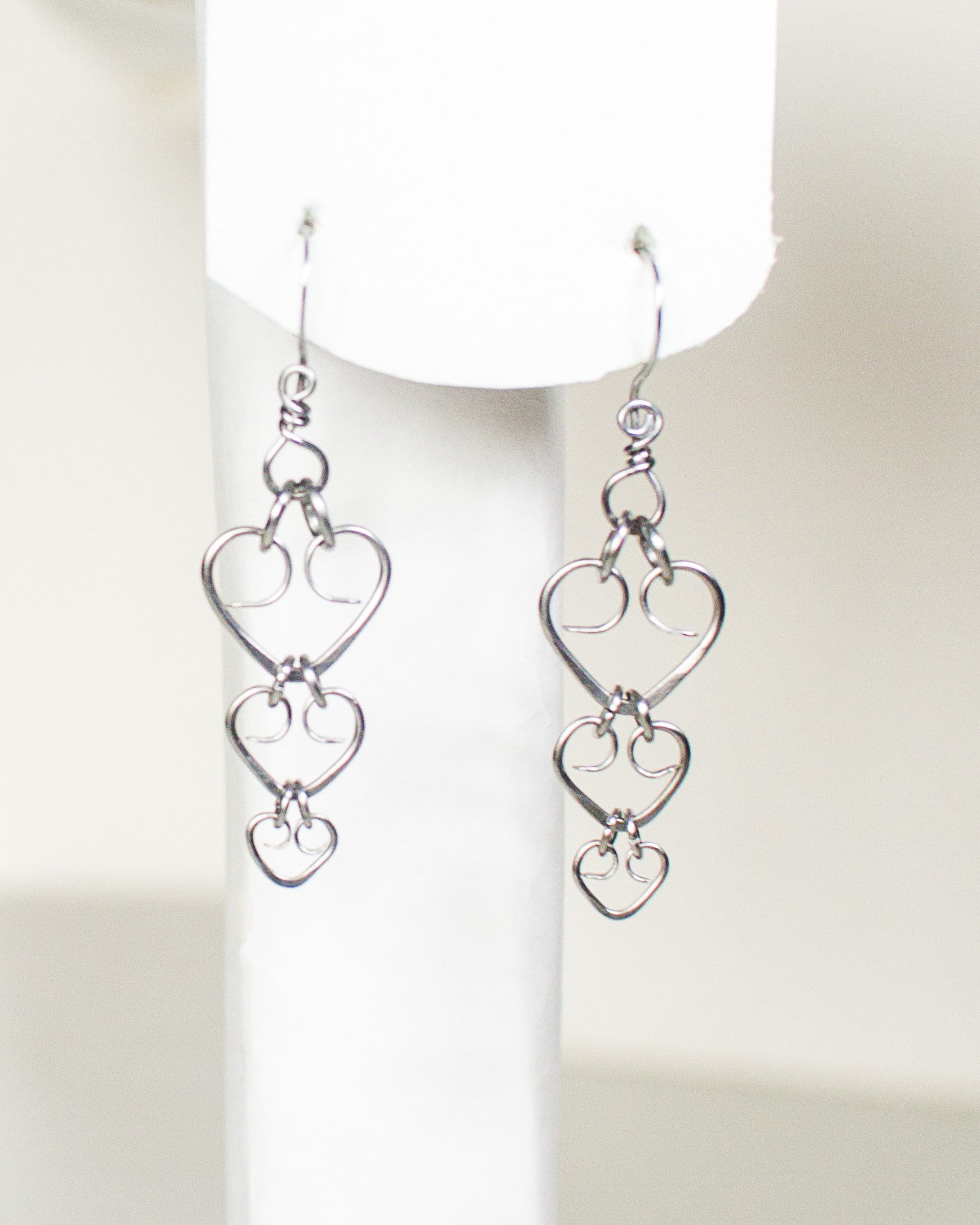 Pair of steel heart-shaped earrings on a white background