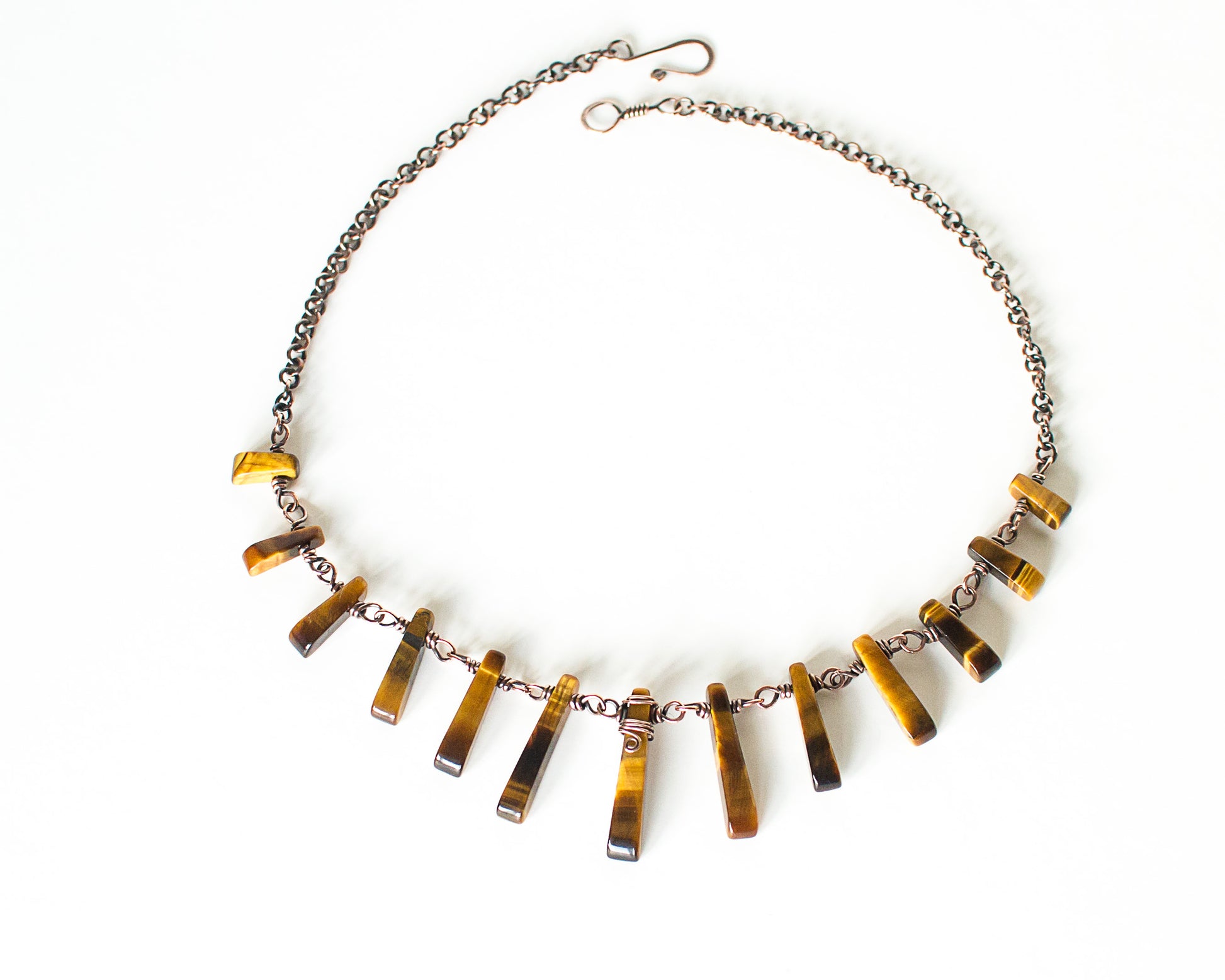 Necklace with tigerseye bar-shaped beads on a white background