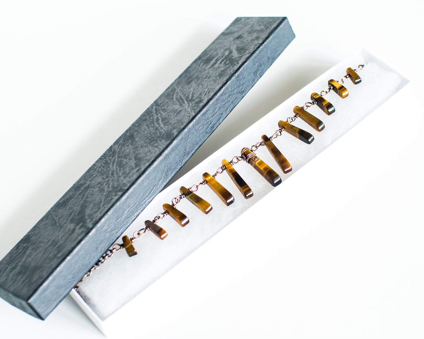 Tiger eye necklace in a black box on a white background