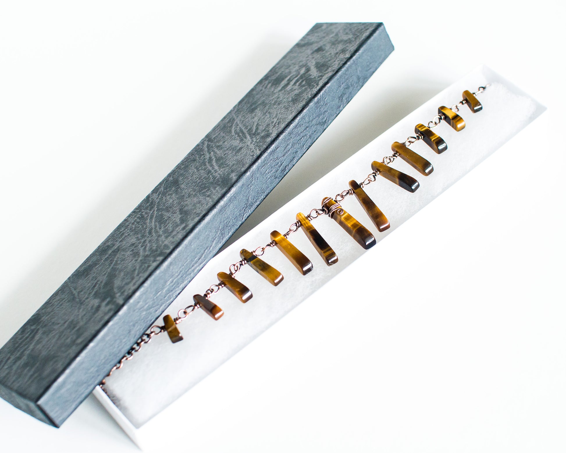 Tiger eye necklace in a black box on a white background