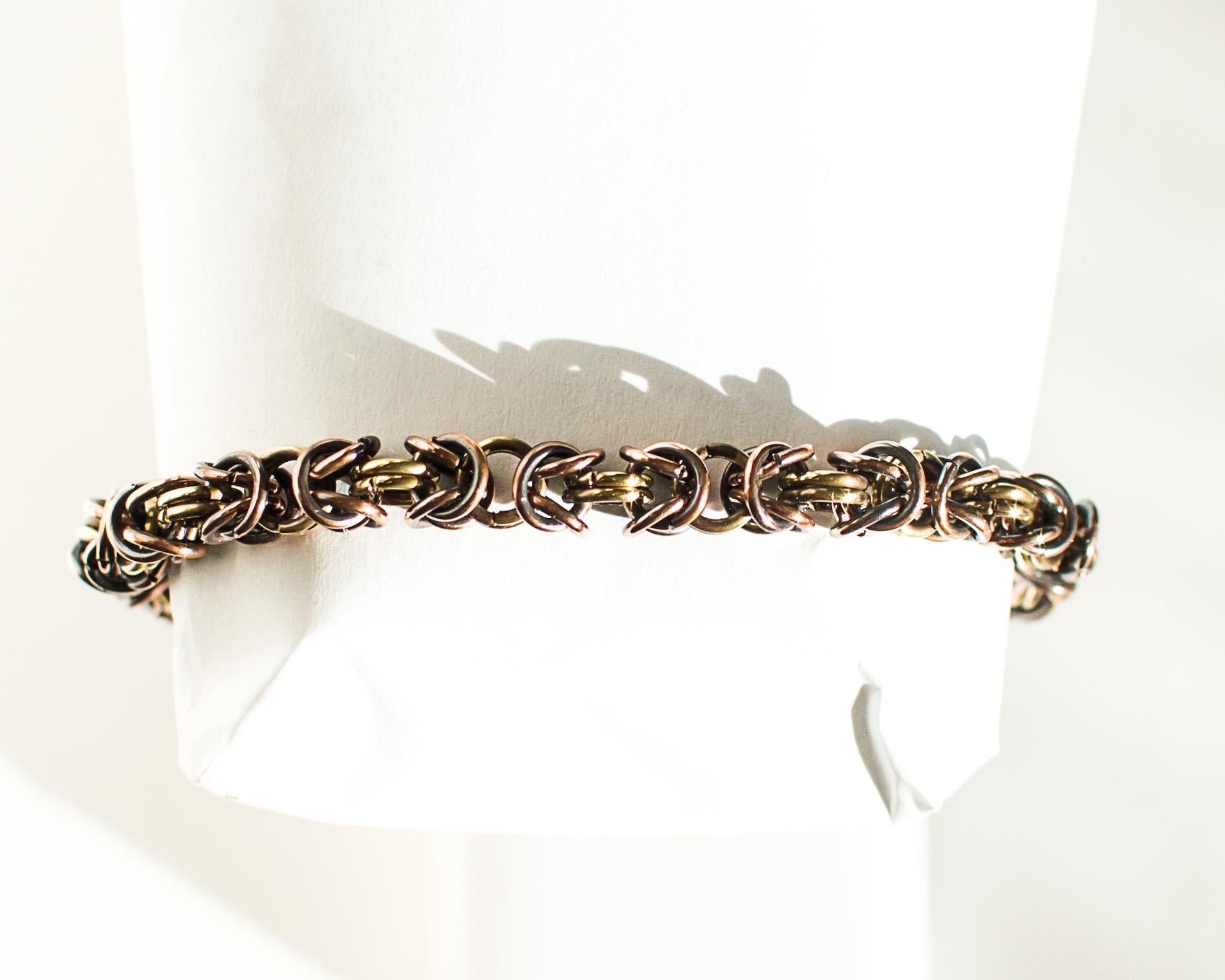 Copper and brass chain bracelet on a white mannequin wrist.