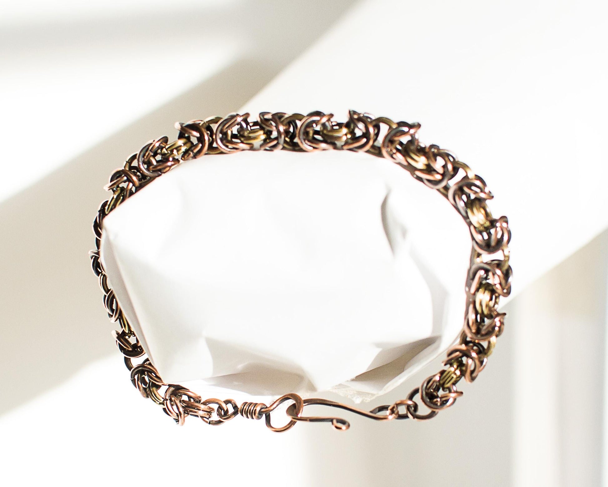 Copper and Brass chain bracelet on a white surface.
