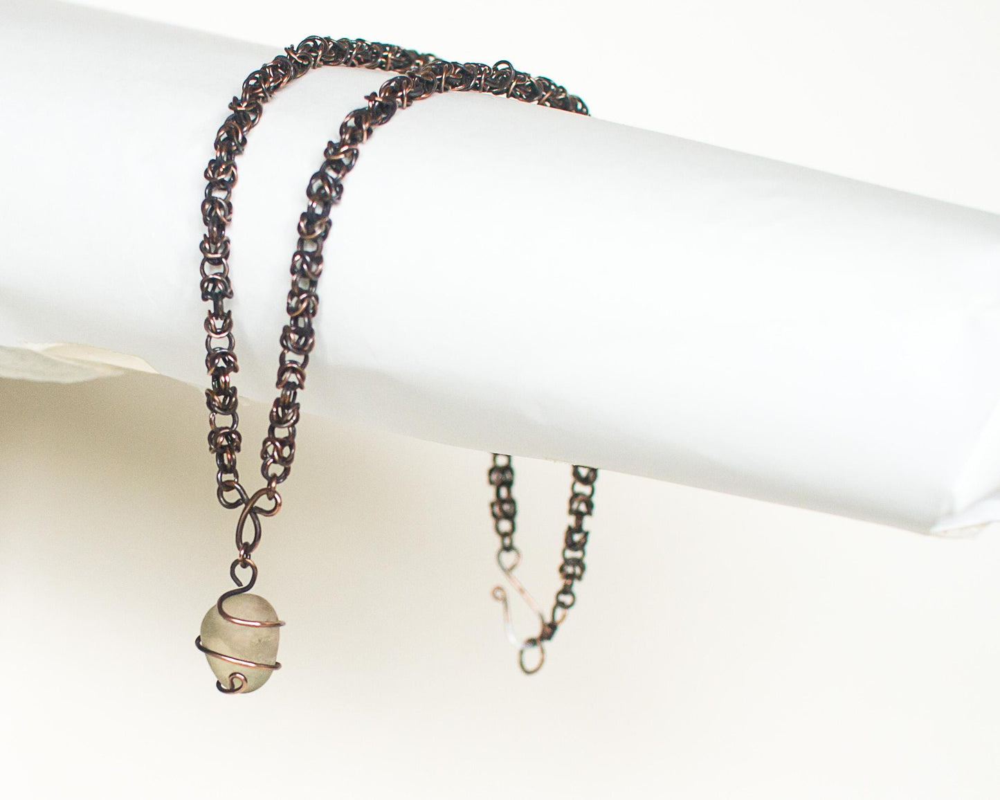coper chain necklace with baroque stone pendant on a white surface