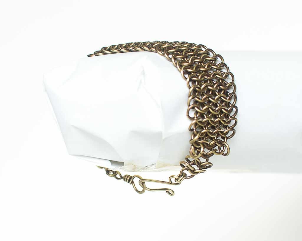 Brass chainmaille bracelet on a white background